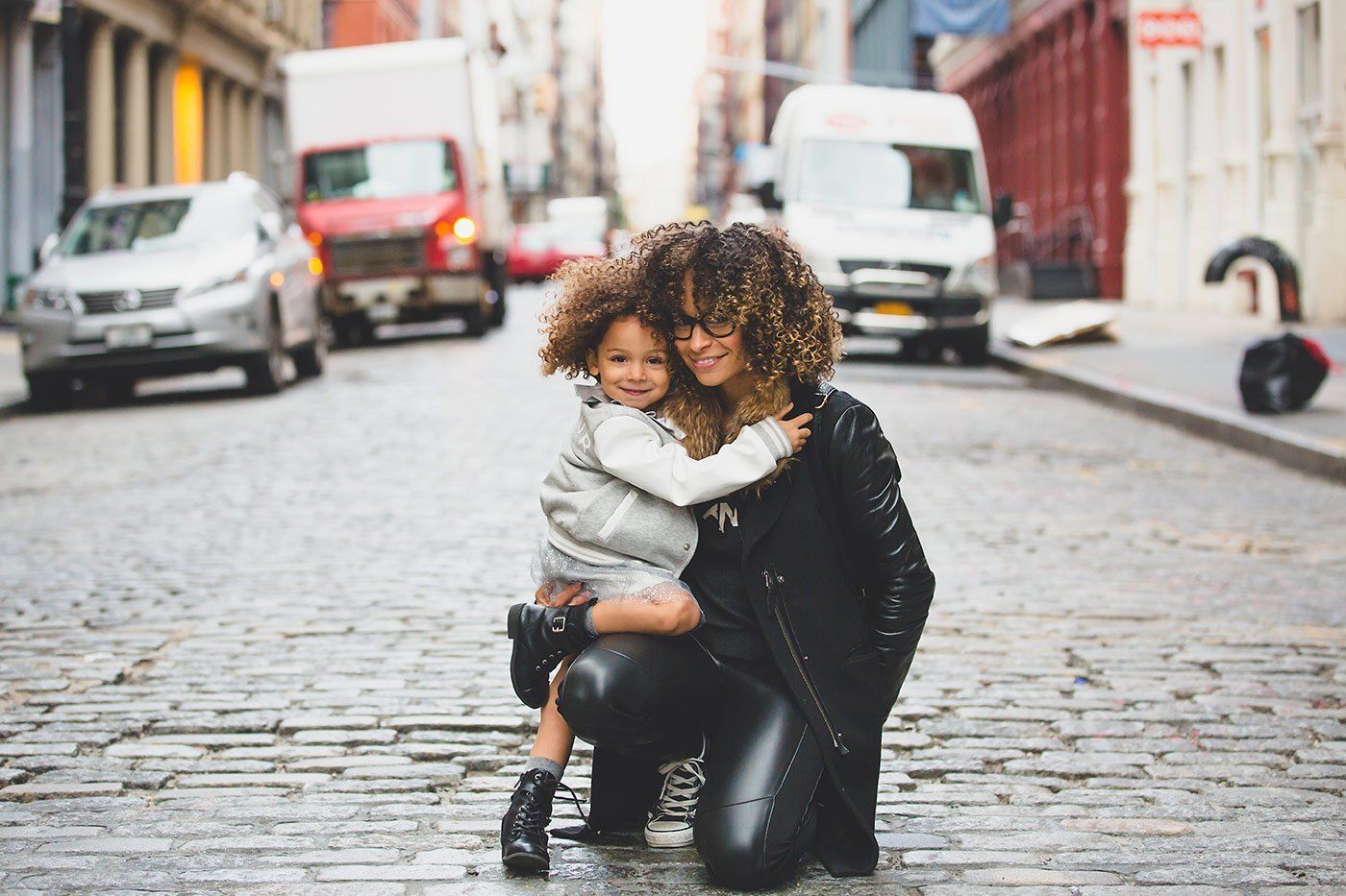 Mother hugging her child on a city street representing child custody and family-related investigation services