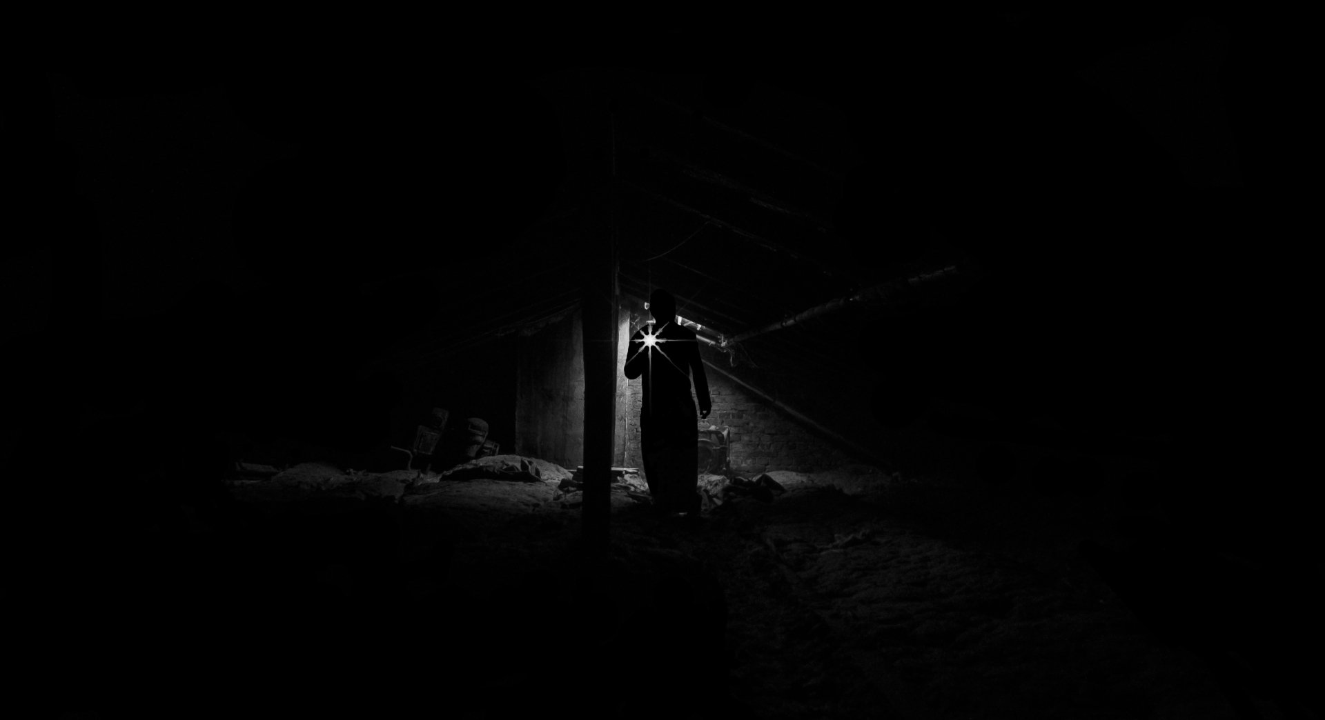Investigator using a flashlight at night representing missing persons and surveillance investigation services