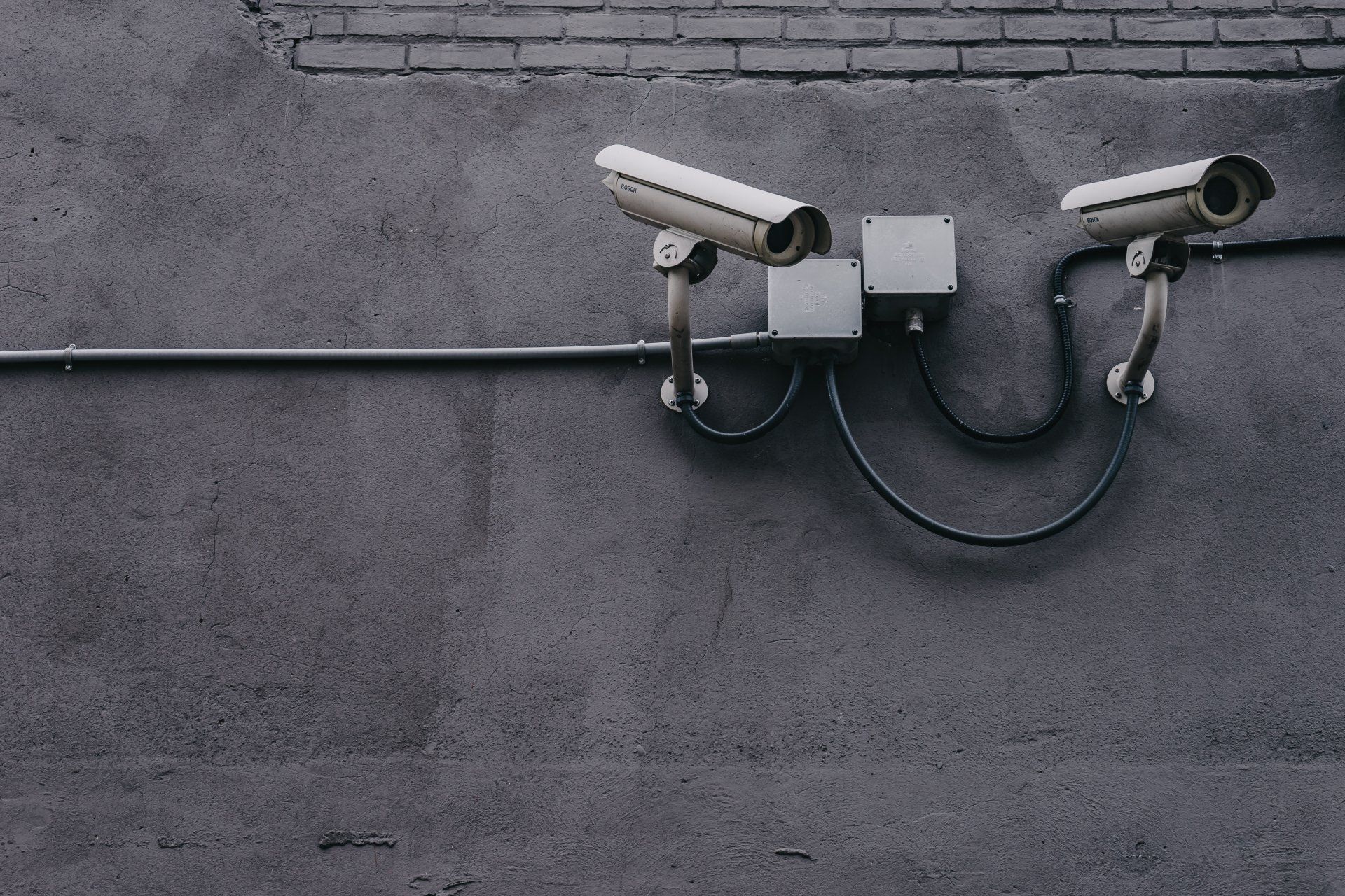 Security cameras mounted on a wall representing professional surveillance and investigation services